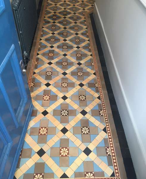 A view of a cleaned Victorian floor containing encaustic and plain blue and buff tiles