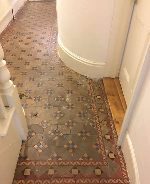 Victorian tiled floor with cracks and loose tiles