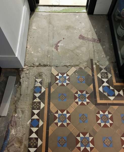 A corner of a Victorian tiled floor with tiles removed