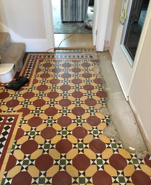 Red and yellow tiled mosaic floor in downstairs hallway of a UK home