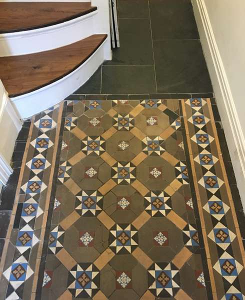 Mosaic hallway tiled floor next to retrofitted black slate tiles