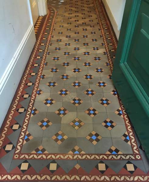 Clean hallway Victorian tiled floor with blue accents and red border