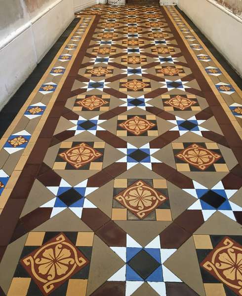 Closeup of a clean and shiny Victorian geometric tiled floor in a London home