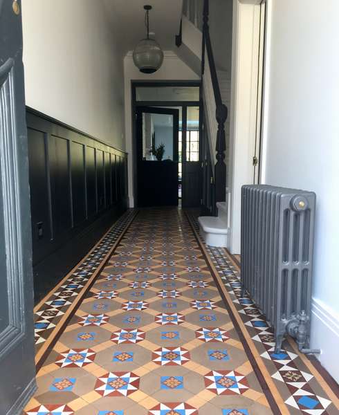 A view down the hallway showing Victorian geometric tiled flooring